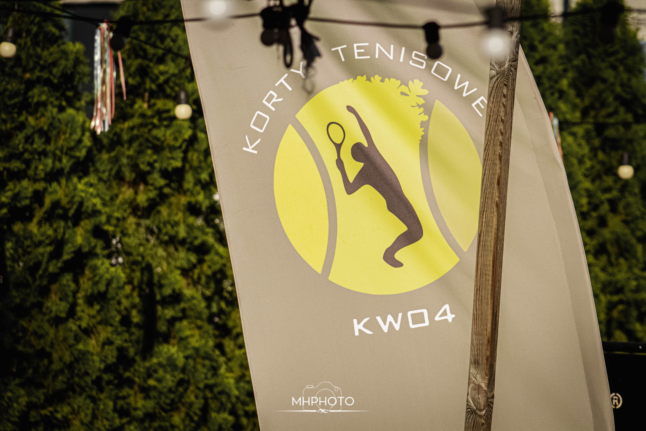 Kort tenisowy, logo z zawodnikiem i napisem KW04.